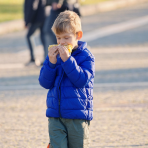 boy eating corn on the cob cooked on the stove